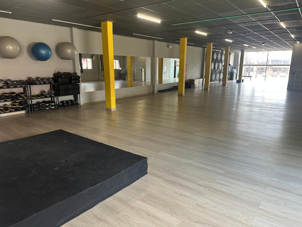 Estúdio de treino amplo com piso vinílico Kapazi Berlim em madeira clara